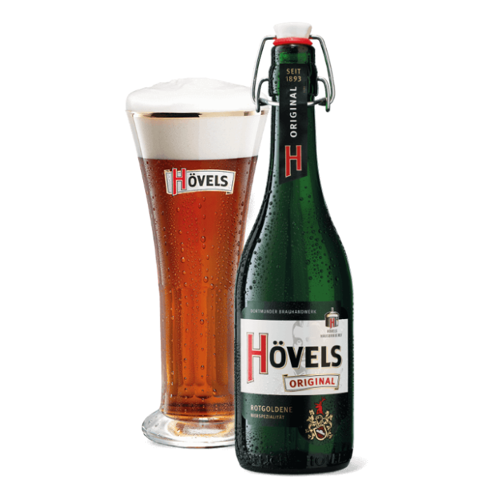 Ein volles Bierglas steht neben einer geschlossenen grünen Flasche auf weißem Hintergrund.