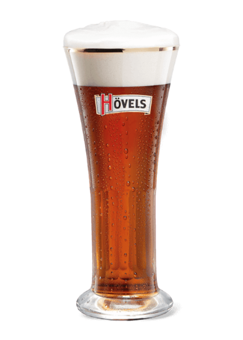 Ein Glas Bier mit Schaumkrone steht vor neutralem Hintergrund. Das Getränk hat eine Bernsteinfarbe und ist sprudelnd.